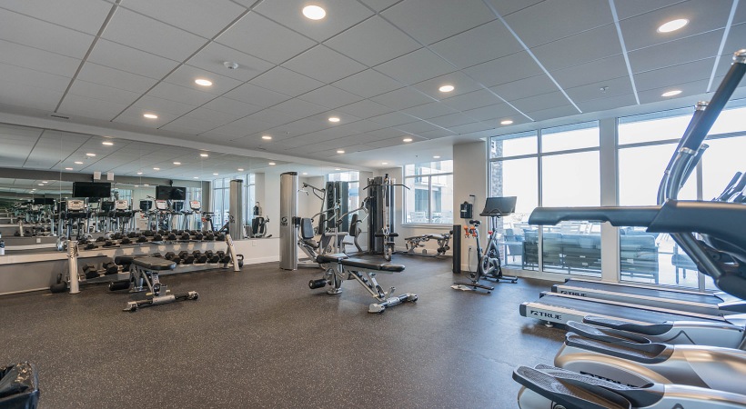 brightly lit fitness center with floor-to-ceiling windows